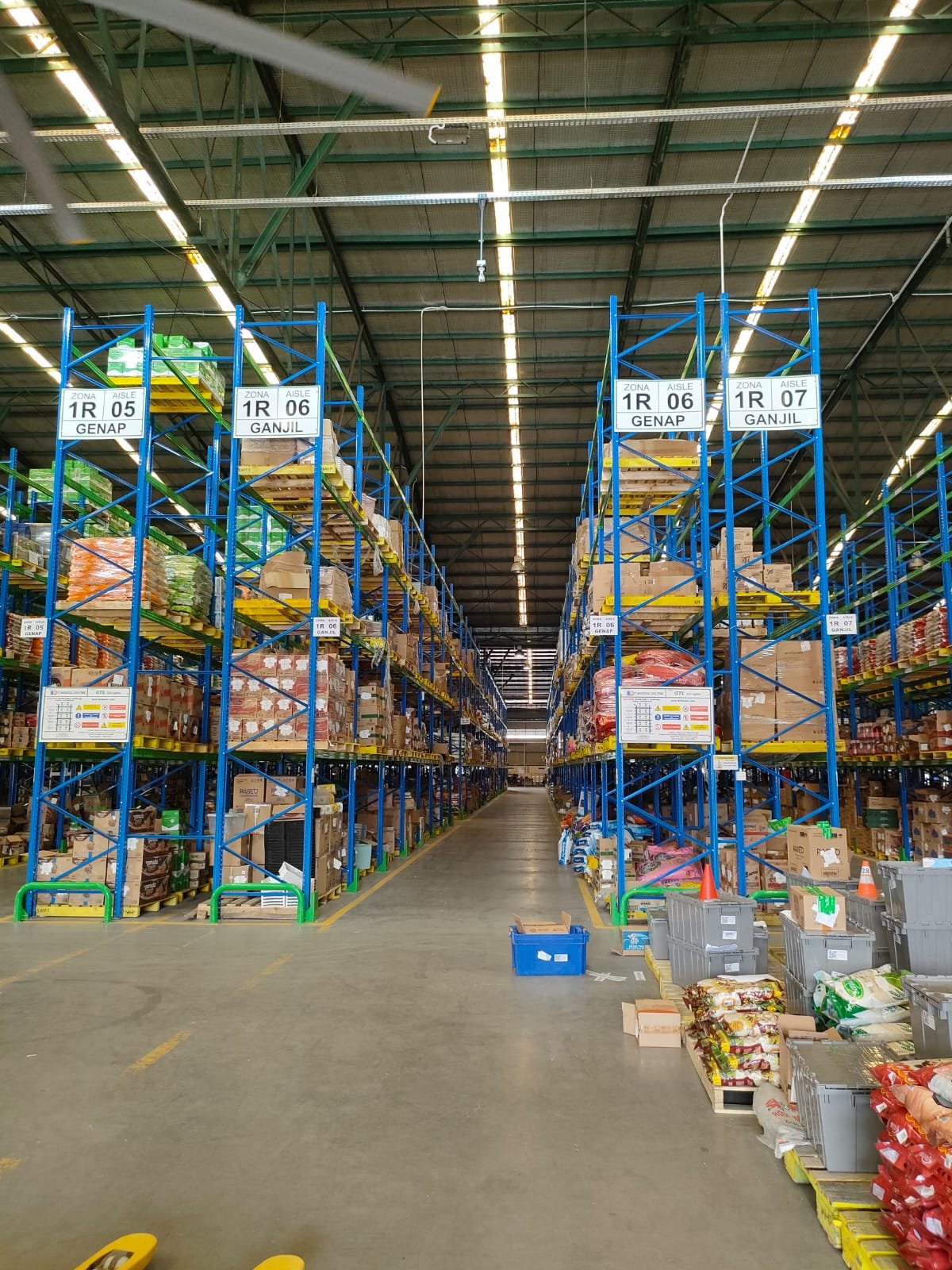 Petugas memeriksa stok di rak gudang FMCG berlabel zona ganjil genap