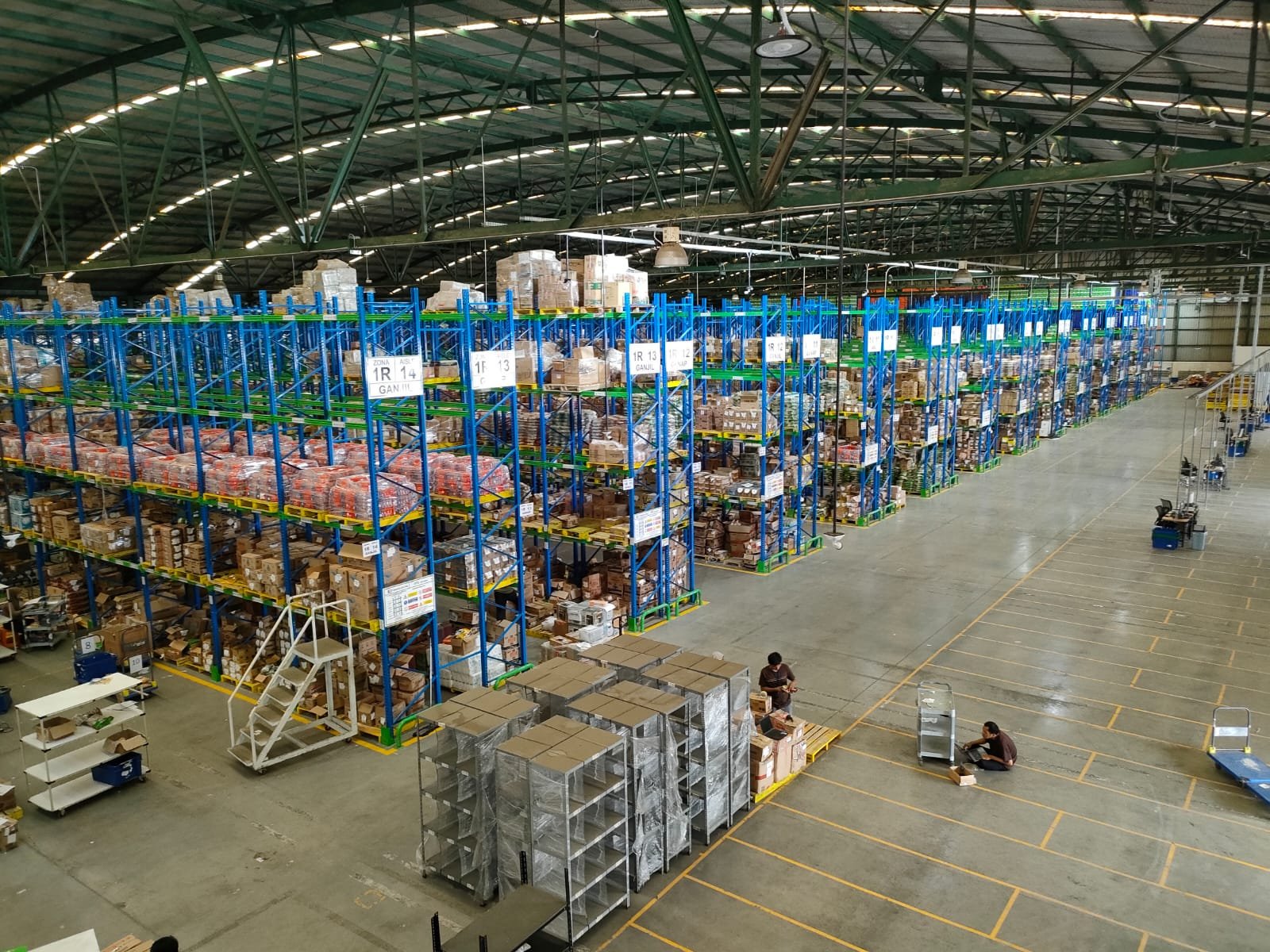Rak gudang FMCG dilihat dari atas dengan lorong panjang