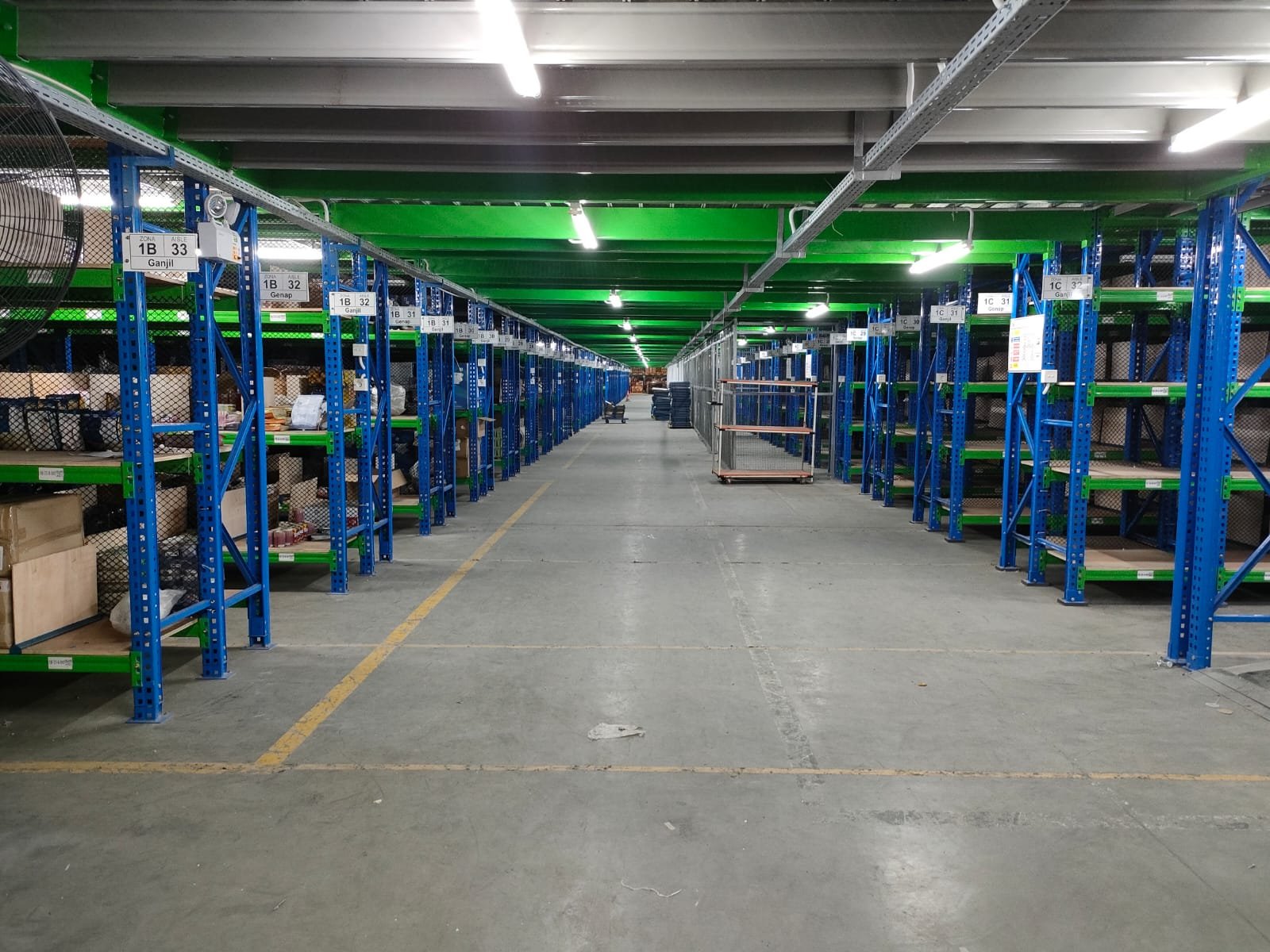 Area mezzanine rak gudang FMCG dengan meja kerja staf di bawahnya